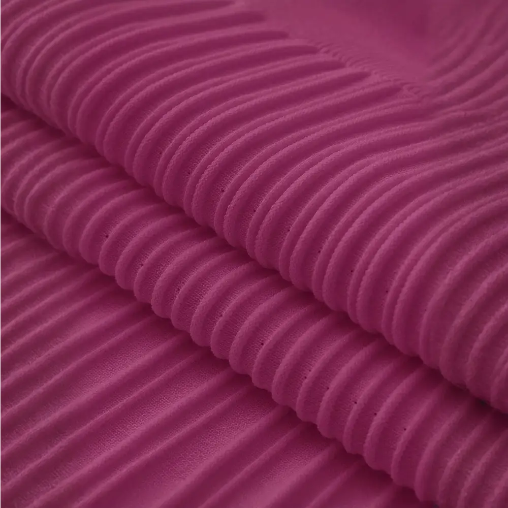 Gros plan sur le tissu en tricot violet de la robe de cocktail hiver. Le tissu est finement plissé, montrant la texture douce et chaude idéale pour les saisons froides.