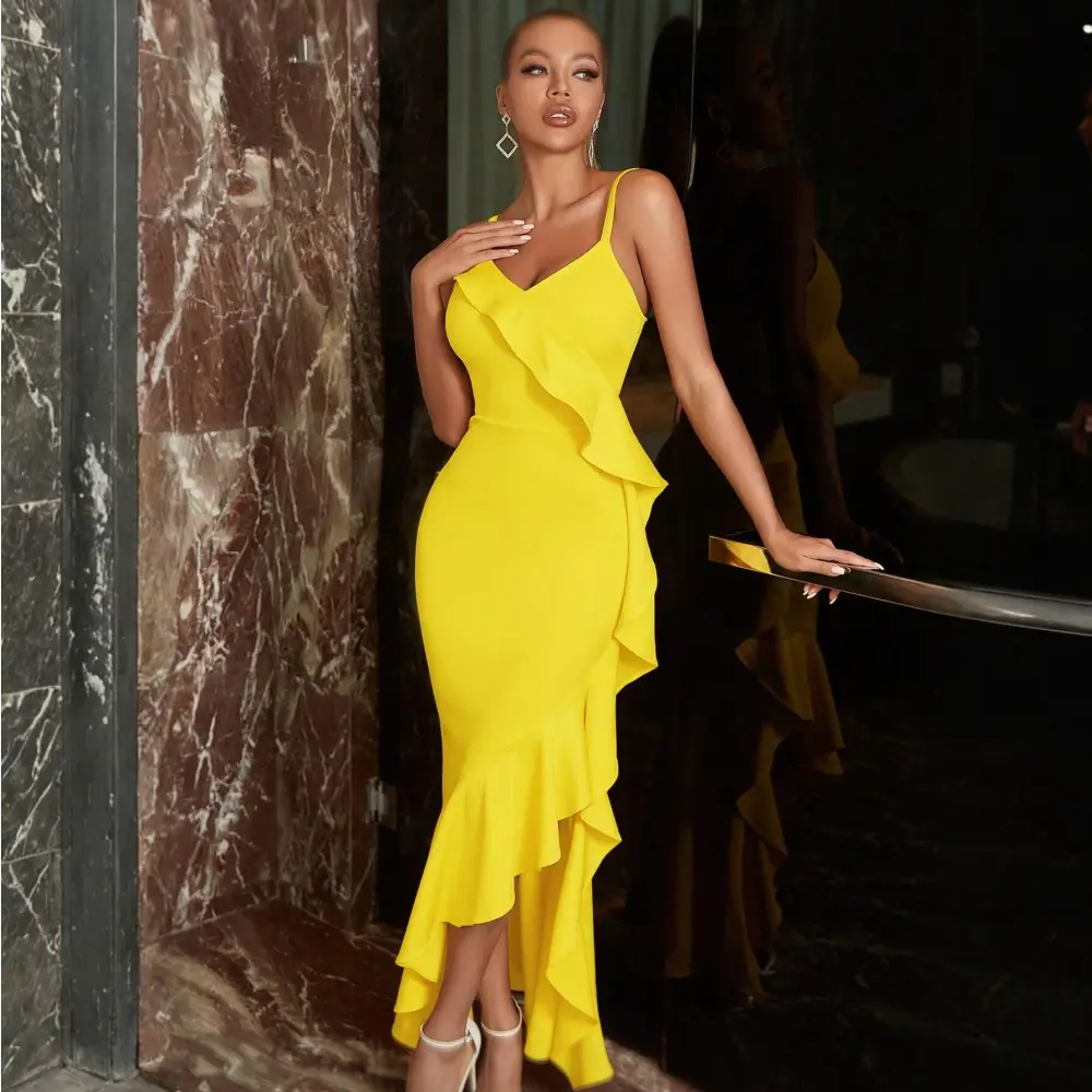 robe cocktail jaune elegante porte par un mannequin. La robe est sans manches avec des bretelles fines et un décolleté en V. La coupe moulante épouse la silhouette et est ornée de volants asymétriques qui ajoutent du mouvement. Le mannequin porte des boucles d’oreilles pendantes et des sandales à talons blancs, parfaites pour une soirée estivale.