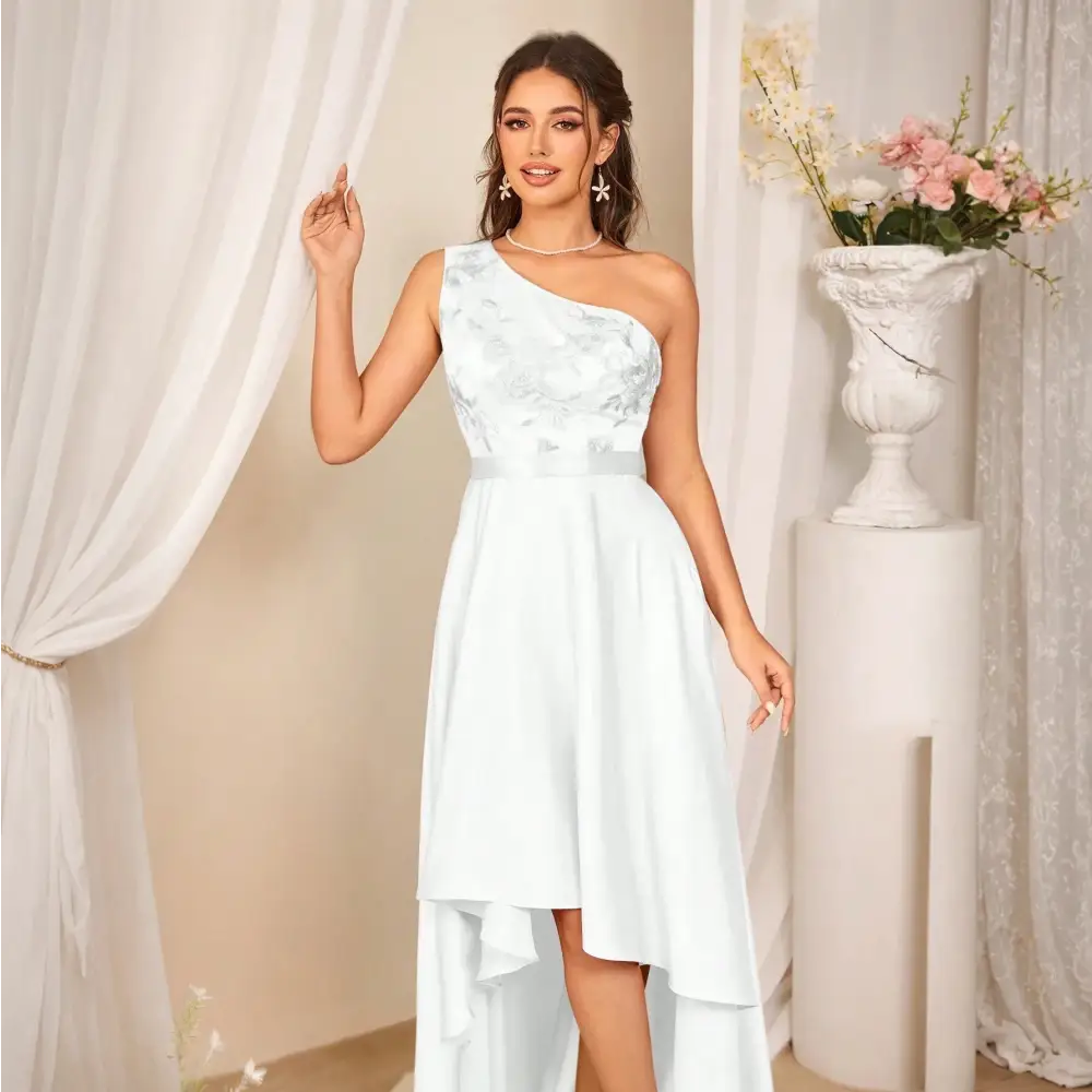 Femme portant une robe de cocktail longue blanche, vue de face, avec une épaule dénudée et des motifs floraux.