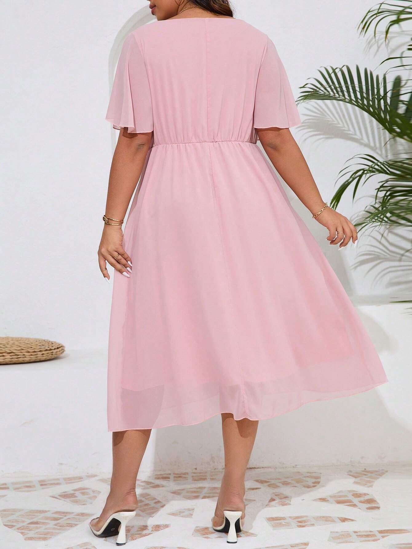 Image de dos de la robe cocktail grande taille en chiffon rose avec une ceinture élastique à la taille.