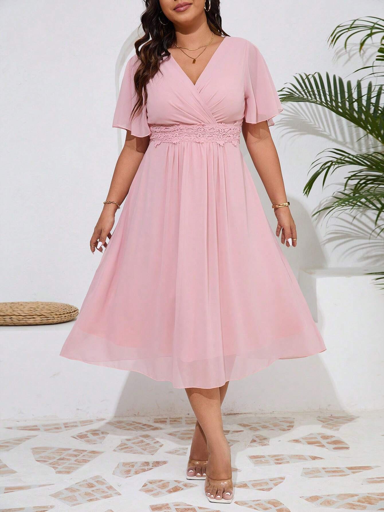 Image de la robe cocktail grande taille en chiffon rose vue de face, portée par un mannequin.