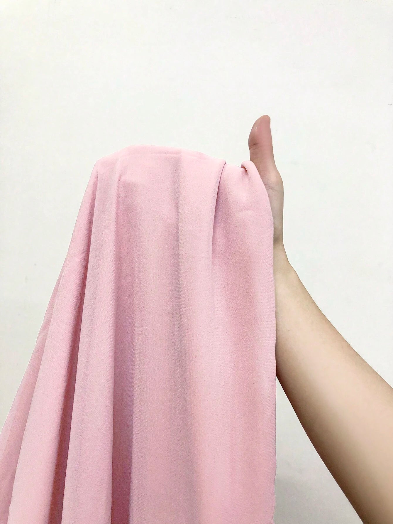 Image en gros plan du tissu en chiffon rose de la robe cocktail grande taille, montrant sa texture douce et fluide.