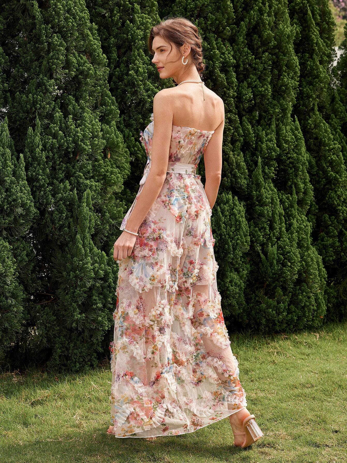 Vue de dos d'une élégante robe cocktail mariage bohème chic, avec un imprimé floral délicat, sans bretelles et ceinturée à la taille, portée par une femme dans un jardin verdoyant.