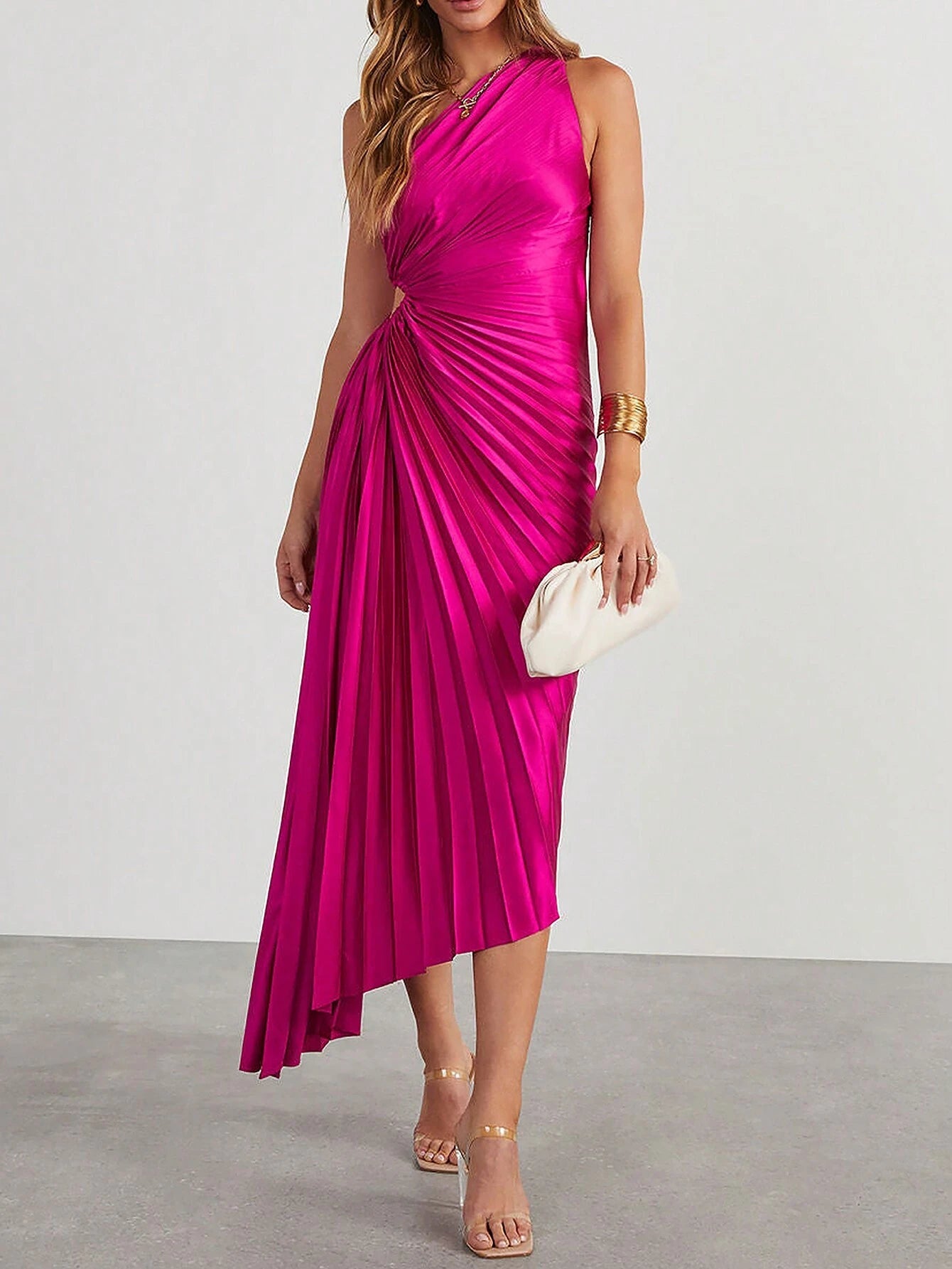 Une robe cocktail satin de couleur fuchsia vue de face, portée par une femme en entier. La robe est sans manches, présente des plis élégants et une coupe asymétrique avec une ouverture sur le côté de la taille.