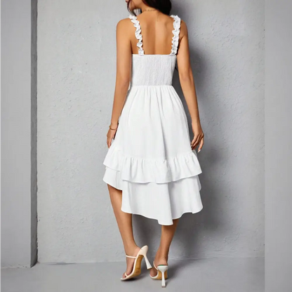 Robe cocktail chic courte vue de face, avec jupe à volants et bretelles à froufrous.