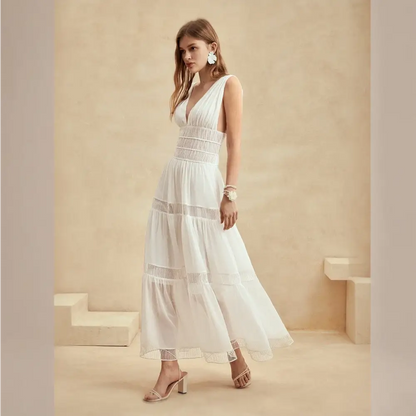 Une somptueuse robe cocktail longue en soie blanche vue de côté, avec un décolleté en V profond, une coupe cintrée à la taille et des détails en dentelle pour un look glamour et féminin.