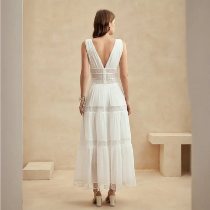 Une élégante robe cocktail longue en soie blanche vue de dos, avec un décolleté profond en V, mettant en valeur le dos et soulignant la taille pour une allure sophistiquée.