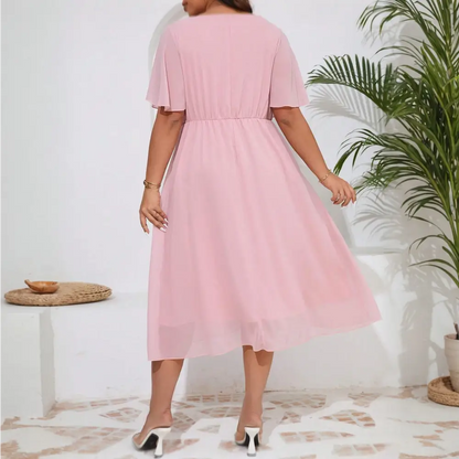Image de dos de la robe cocktail grande taille en chiffon rose avec une ceinture élastique à la taille.