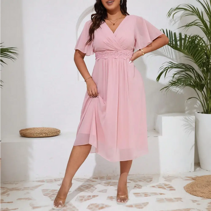 Image de face de la robe cocktail grande taille en chiffon rose avec des manches courtes et un décolleté en V.