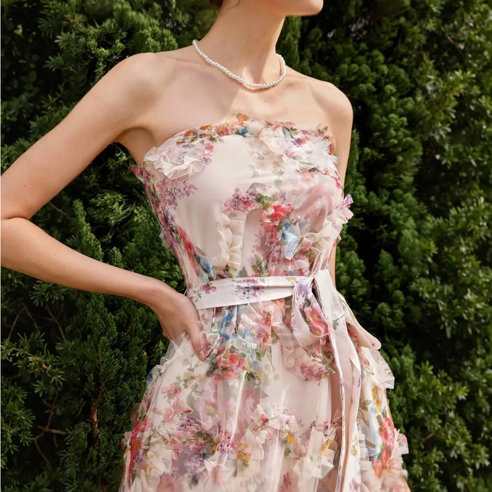 Gros plan sur une robe cocktail mariage bohème chic, mettant en évidence les détails floraux et la texture délicate du tissu, avec une ceinture assortie à la taille.