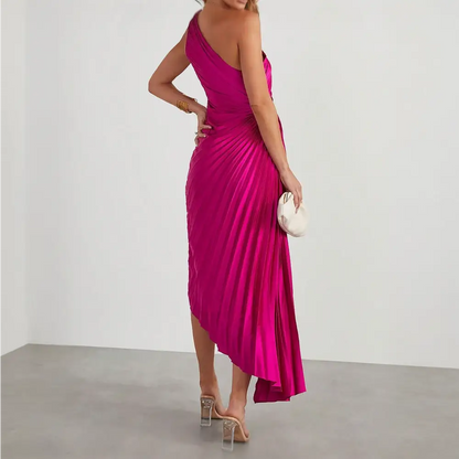 Une robe cocktail satin de couleur fuchsia vue de dos. La robe est sans manches et présente une coupe asymétrique avec une ouverture sur le côté de la taille.